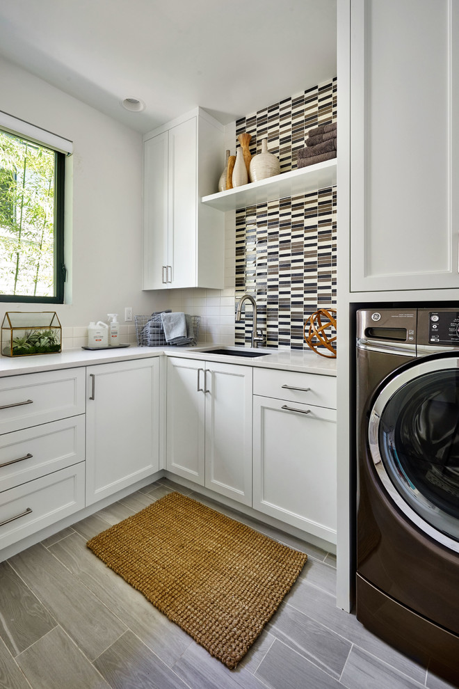 Große Moderne Waschküche in L-Form mit Unterbauwaschbecken, Schrankfronten im Shaker-Stil, weißen Schränken, Quarzwerkstein-Arbeitsplatte, weißer Wandfarbe, Porzellan-Bodenfliesen und Waschmaschine und Trockner nebeneinander in Portland
