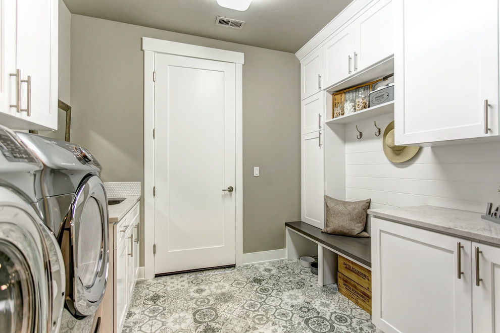 Immagine di una sala lavanderia country con lavello sottopiano, ante in stile shaker, ante bianche, pareti grigie, lavatrice e asciugatrice affiancate, pavimento grigio e top grigio