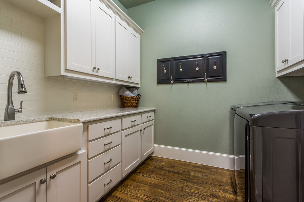 Large transitional galley dark wood floor dedicated laundry room photo in Dallas with a farmhouse sink, shaker cabinets, white cabinets, green walls and a side-by-side washer/dryer