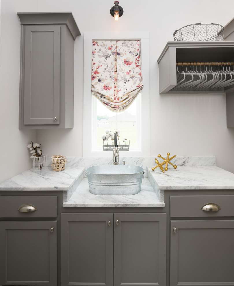 Exempel på en liten klassisk grå grått tvättstuga, med en enkel diskho, luckor med infälld panel och marmorbänkskiva