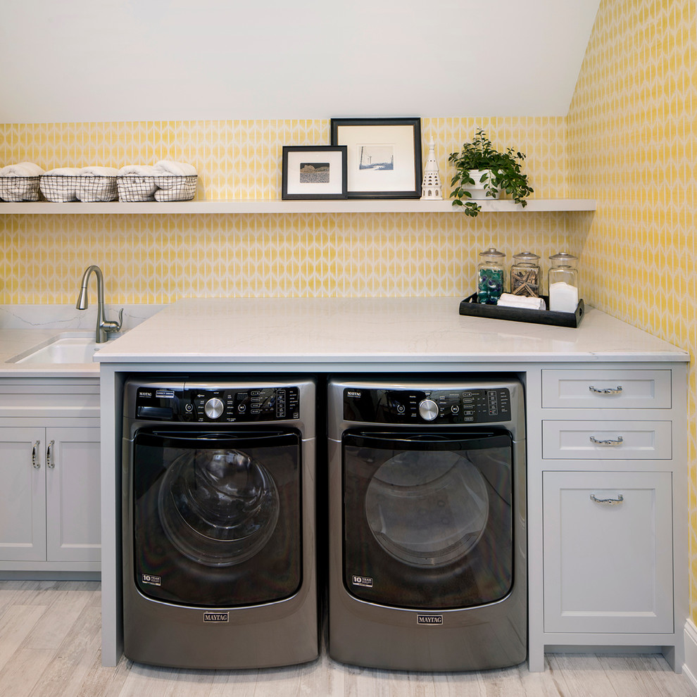 Idee per una lavanderia tradizionale con top in quarzo composito, pareti gialle, lavatrice e asciugatrice affiancate, lavello sottopiano, ante in stile shaker, ante grigie e pavimento grigio