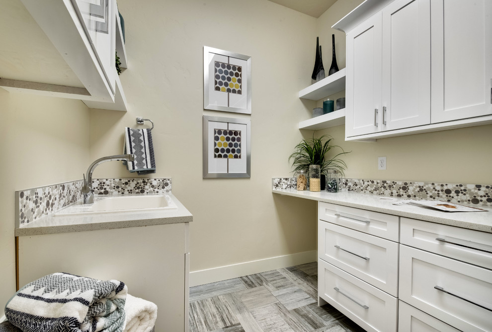 This is an example of a medium sized modern u-shaped utility room in Boise with a single-bowl sink, shaker cabinets, white cabinets, engineered stone countertops, white walls, porcelain flooring and a side by side washer and dryer.