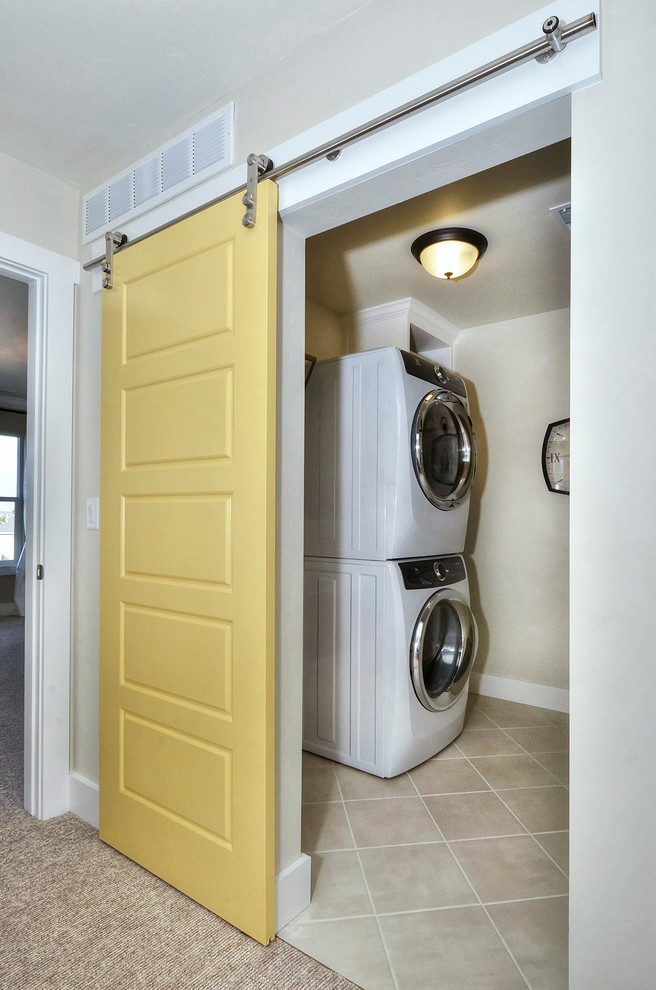 Example of an arts and crafts ceramic tile dedicated laundry room design in Denver with a stacked washer/dryer