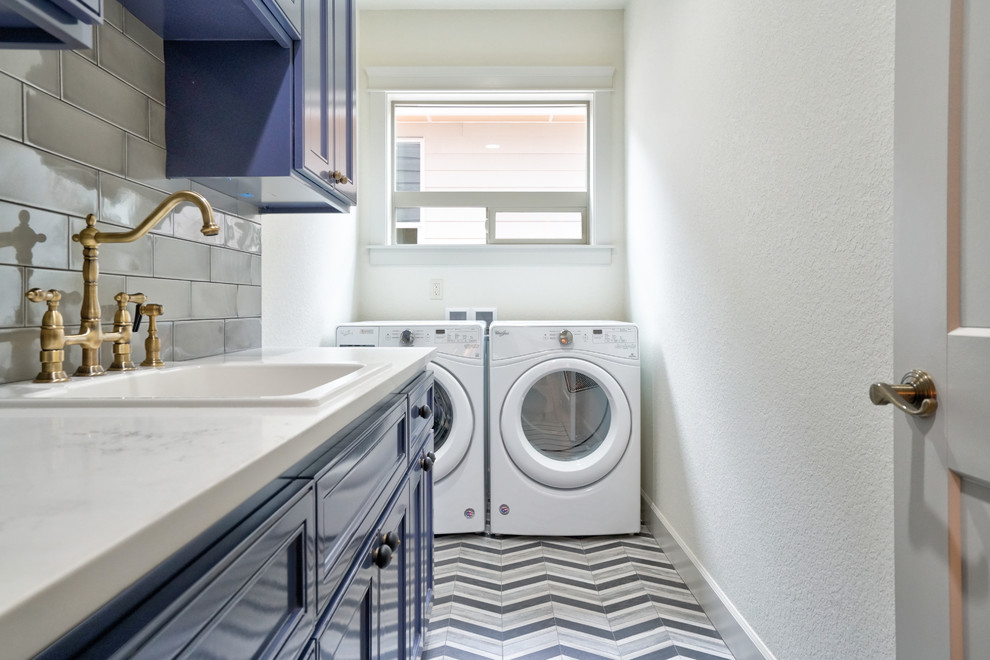 ポートランドにある小さなトランジショナルスタイルのおしゃれな洗濯室 (I型、ドロップインシンク、落し込みパネル扉のキャビネット、青いキャビネット、珪岩カウンター、ベージュの壁、左右配置の洗濯機・乾燥機、マルチカラーの床、白いキッチンカウンター) の写真