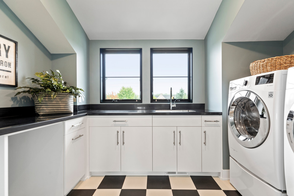 Inspiration för en stor funkis svarta u-formad svart tvättstuga enbart för tvätt, med en undermonterad diskho, släta luckor, vita skåp, bänkskiva i kvarts, blå väggar, klinkergolv i keramik, en tvättmaskin och torktumlare bredvid varandra och flerfärgat golv