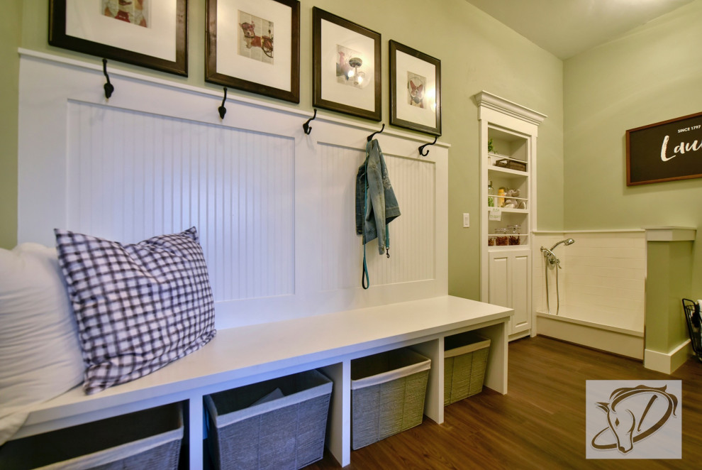 デンバーにある高級な広いトランジショナルスタイルのおしゃれな家事室 (緑の壁、クッションフロア、左右配置の洗濯機・乾燥機、茶色い床、白いキッチンカウンター) の写真