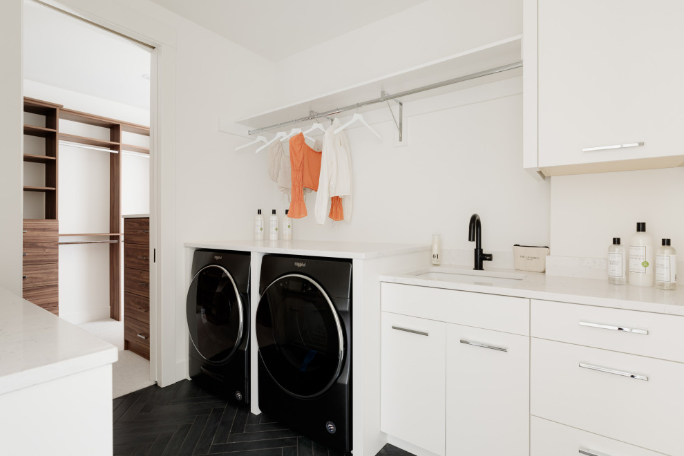 Idéer för att renovera en funkis vita l-formad vitt tvättstuga enbart för tvätt, med en undermonterad diskho, vita skåp, bänkskiva i kvartsit, vita väggar och en tvättmaskin och torktumlare bredvid varandra