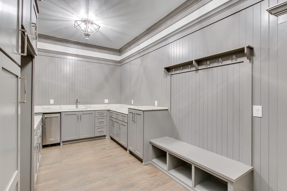 Idee per un'ampia sala lavanderia minimalista con ante in stile shaker, ante grigie, top in granito, pareti grigie, pavimento in legno massello medio, lavatrice e asciugatrice affiancate e top bianco