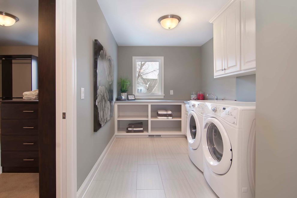 ミネアポリスにある中くらいなおしゃれな家事室 (ドロップインシンク、白いキャビネット、グレーの壁、左右配置の洗濯機・乾燥機) の写真