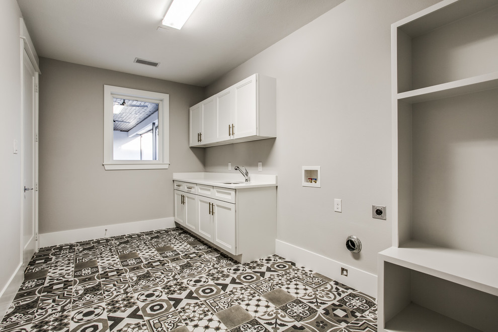 Idéer för att renovera ett stort funkis vit linjärt vitt grovkök, med en undermonterad diskho, luckor med profilerade fronter, vita skåp, marmorbänkskiva, vitt stänkskydd, stänkskydd i marmor, grå väggar, klinkergolv i keramik, en tvättmaskin och torktumlare bredvid varandra och svart golv