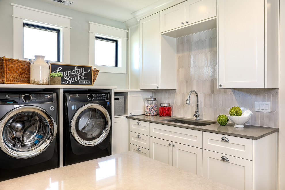 Inspiration för mellanstora lantliga grått tvättstugor enbart för tvätt, med en undermonterad diskho, skåp i shakerstil, vita skåp, bänkskiva i kvarts, grå väggar, klinkergolv i porslin, en tvättmaskin och torktumlare bredvid varandra och grått golv