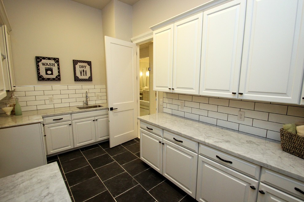 Foto de cuarto de lavado de galera clásico renovado grande con puertas de armario blancas, encimera de mármol y paredes blancas