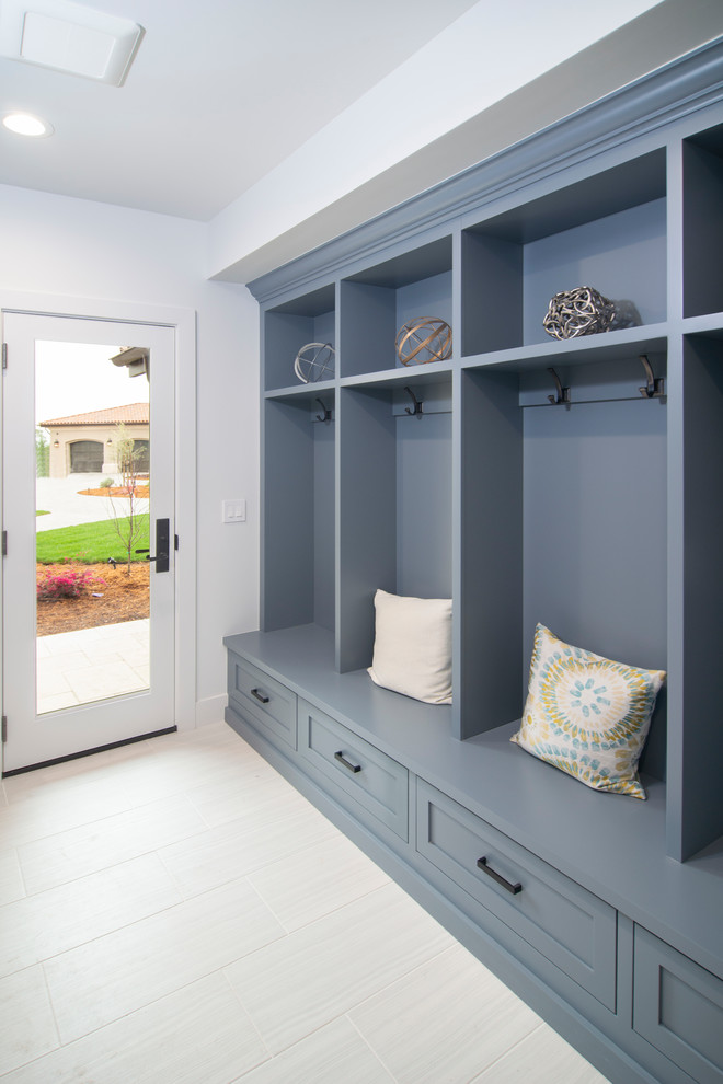 Exemple d'une buanderie parallèle chic avec un placard à porte affleurante et des portes de placard bleues.