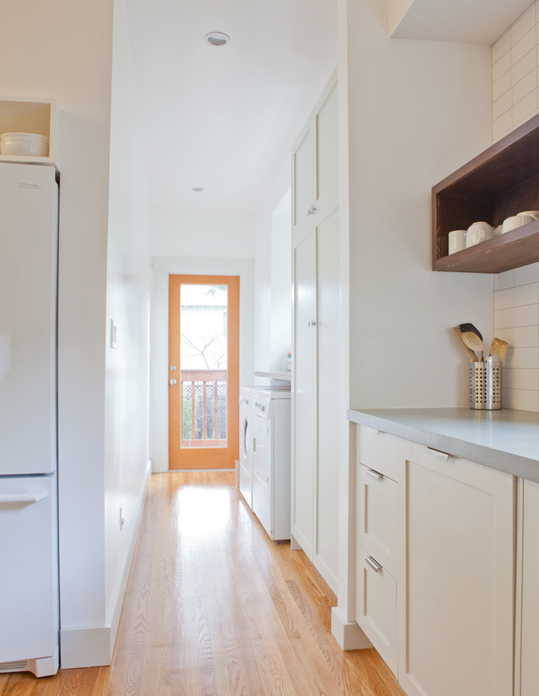 Design ideas for a traditional galley separated utility room in San Francisco with a side by side washer and dryer.