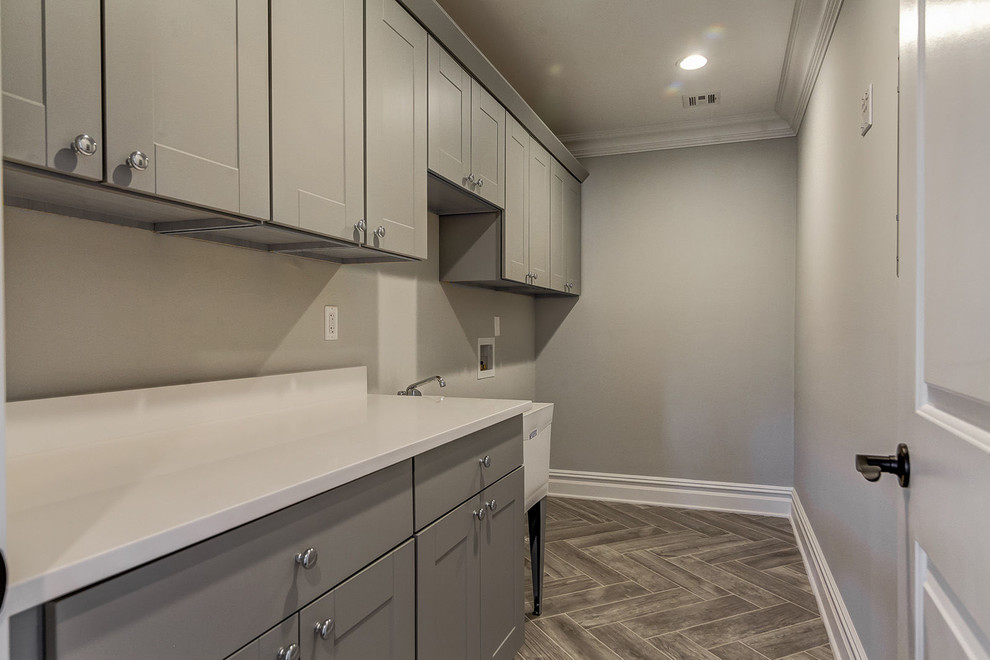 Foto de cuarto de lavado lineal clásico renovado de tamaño medio con paredes grises, suelo de baldosas de cerámica y suelo gris