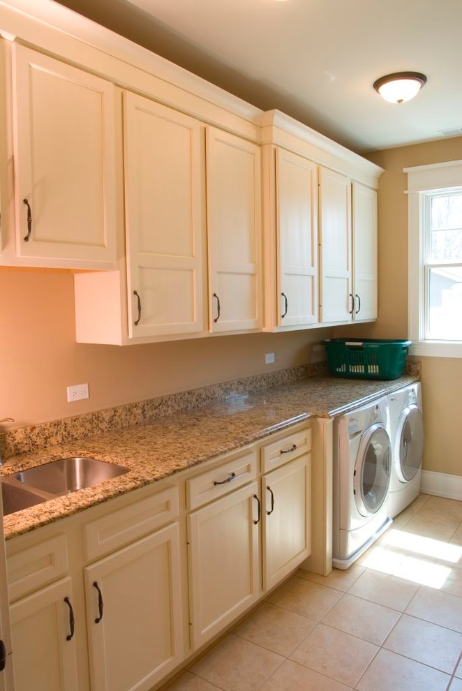 Example of a large arts and crafts single-wall porcelain tile laundry room design in Nashville with an undermount sink, recessed-panel cabinets, white cabinets, granite countertops, beige walls and a side-by-side washer/dryer