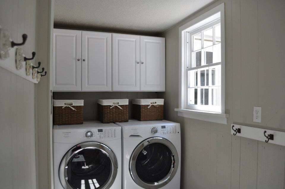 Mid-sized elegant single-wall dedicated laundry room photo in Oklahoma City with recessed-panel cabinets, white cabinets, beige walls and a side-by-side washer/dryer