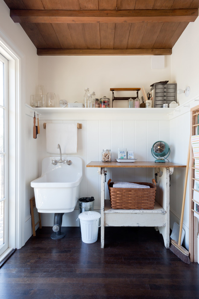Idéer för att renovera en liten lantlig beige beige tvättstuga enbart för tvätt, med en enkel diskho, träbänkskiva, vita väggar och mörkt trägolv