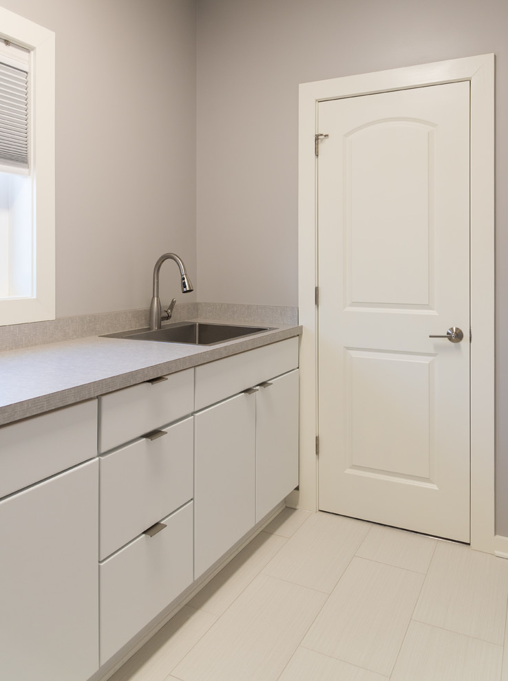 Inspiration for a medium sized modern single-wall separated utility room in DC Metro with a built-in sink, flat-panel cabinets, white cabinets, grey walls and porcelain flooring.