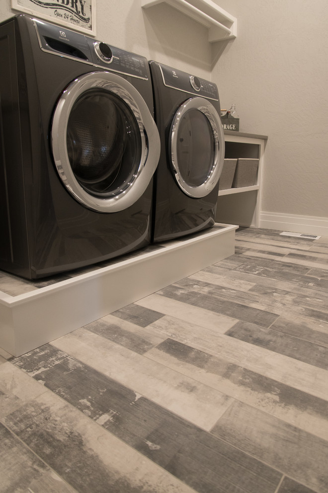 Idéer för att renovera en liten lantlig linjär tvättstuga enbart för tvätt, med grå väggar, en tvättmaskin och torktumlare bredvid varandra, grått golv, klinkergolv i porslin, öppna hyllor, vita skåp och laminatbänkskiva