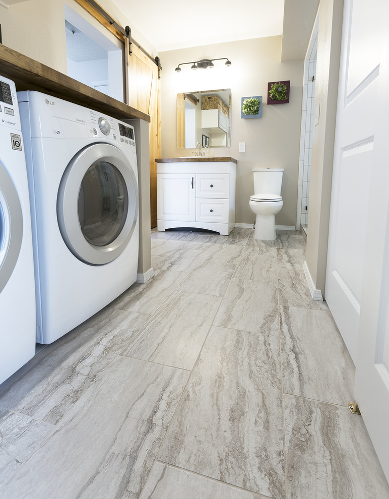 Mid-sized danish galley porcelain tile and multicolored floor utility room photo in Denver with wood countertops, beige walls and a side-by-side washer/dryer