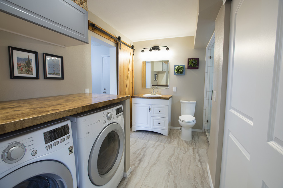 Immagine di una lavanderia multiuso nordica di medie dimensioni con top in legno, pareti beige, pavimento in gres porcellanato, lavatrice e asciugatrice affiancate e pavimento multicolore