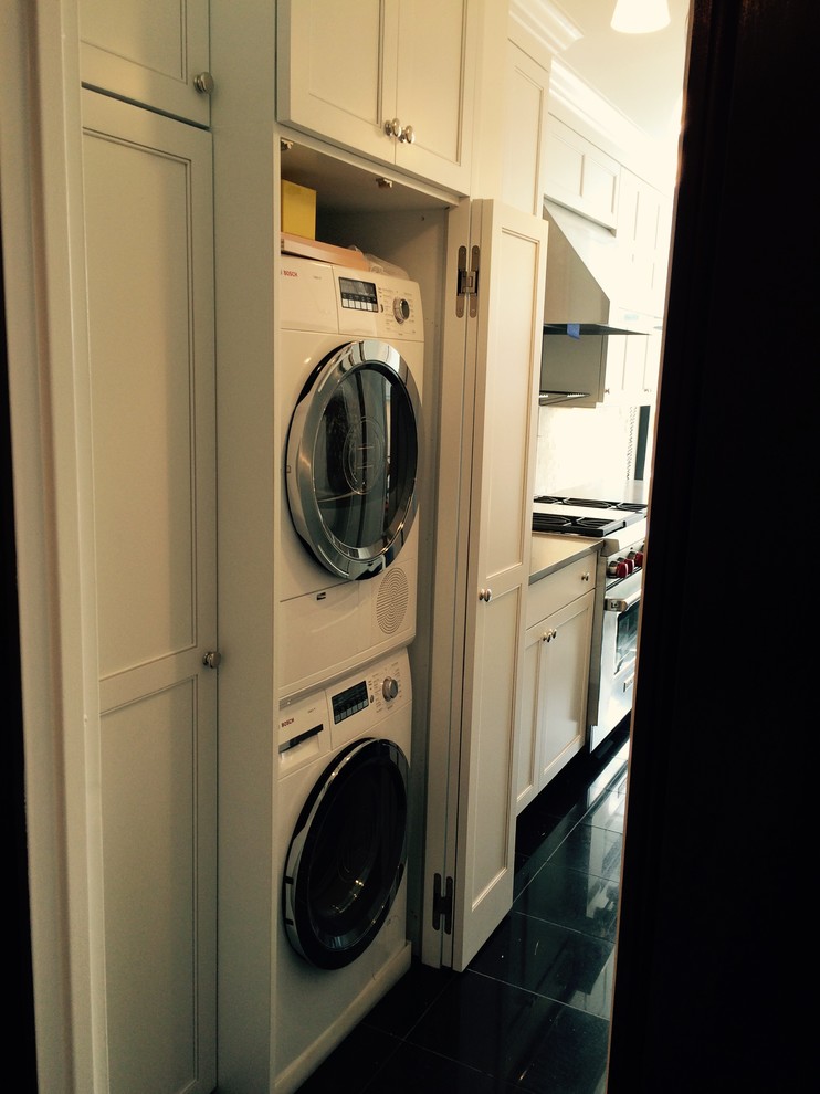 Immagine di una piccola lavanderia multiuso tradizionale con lavello sottopiano, ante in stile shaker, ante bianche, top in granito, pavimento in marmo e lavatrice e asciugatrice nascoste