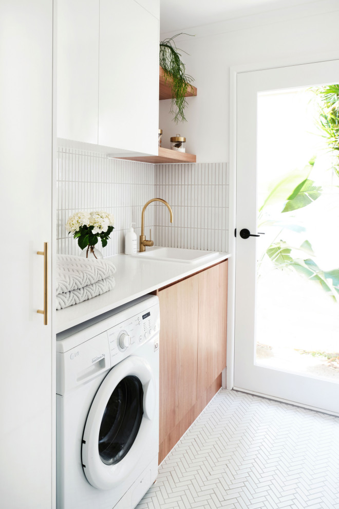 Bild på en funkis vita linjär vitt tvättstuga enbart för tvätt och med garderob, med bänkskiva i kvarts, en nedsänkt diskho, släta luckor, skåp i ljust trä, vita väggar och vitt golv