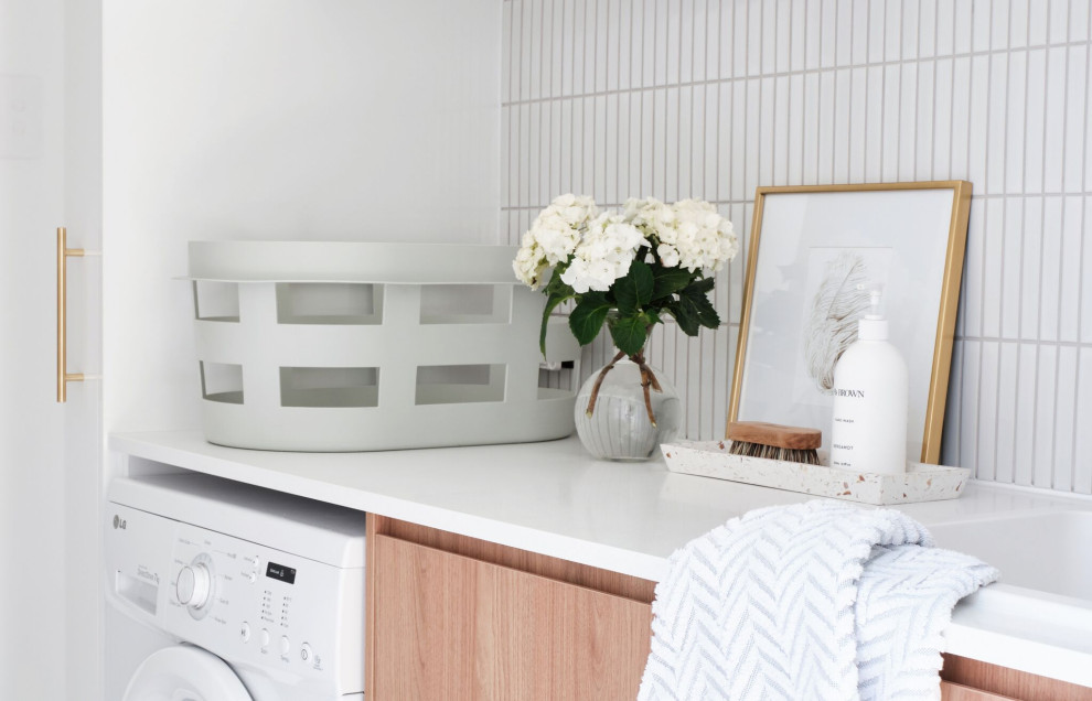 Immagine di una lavanderia minimalista con top in quarzo composito e top bianco