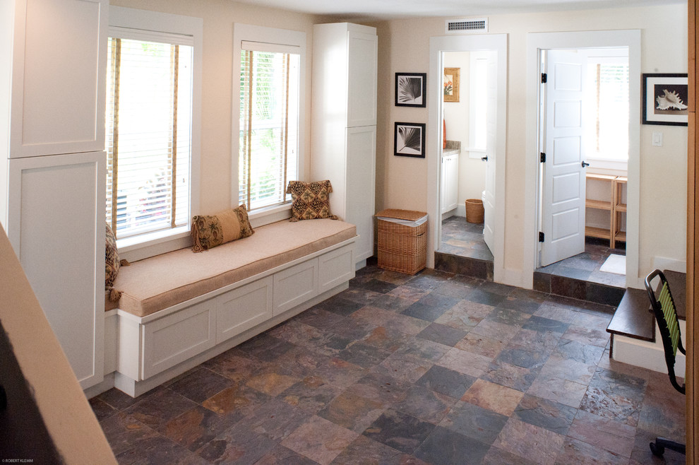 マイアミにある高級な中くらいなトロピカルスタイルのおしゃれな家事室 (シェーカースタイル扉のキャビネット、スレートの床、左右配置の洗濯機・乾燥機) の写真
