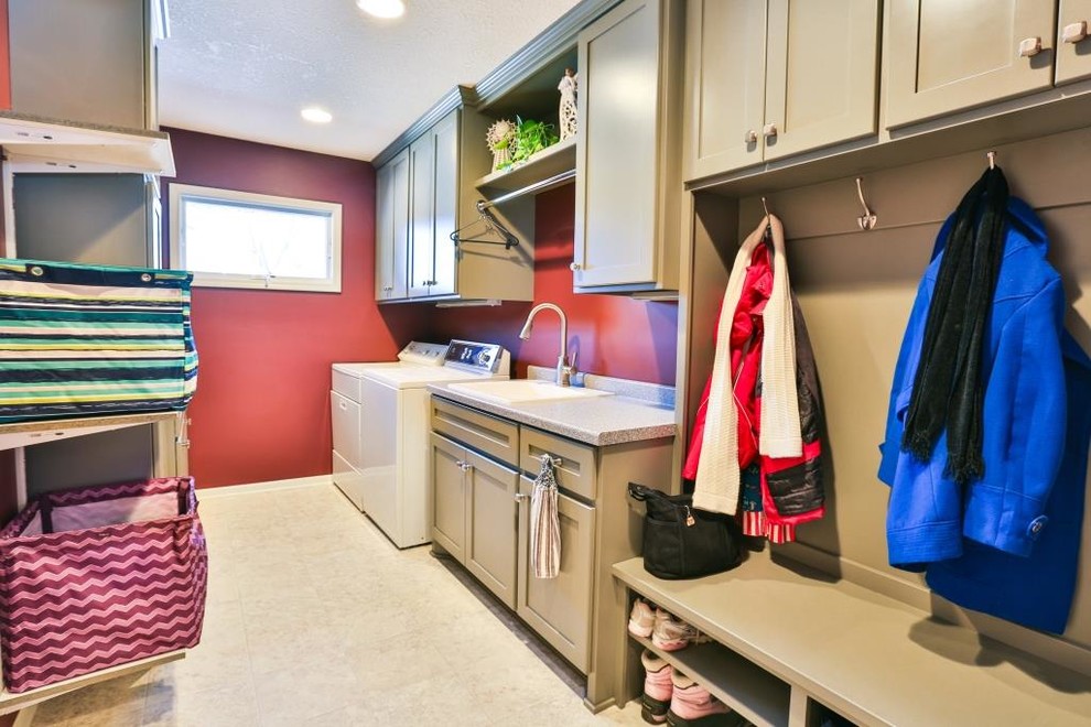 ミネアポリスにある中くらいなトランジショナルスタイルのおしゃれな家事室 (ll型、ドロップインシンク、シェーカースタイル扉のキャビネット、ベージュのキャビネット、御影石カウンター、赤い壁、セラミックタイルの床、左右配置の洗濯機・乾燥機) の写真