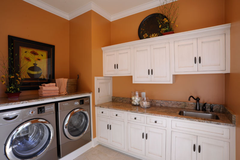 Immagine di una lavanderia multiuso classica con lavello sottopiano, ante in stile shaker, ante bianche, pareti arancioni, lavatrice e asciugatrice affiancate e top multicolore