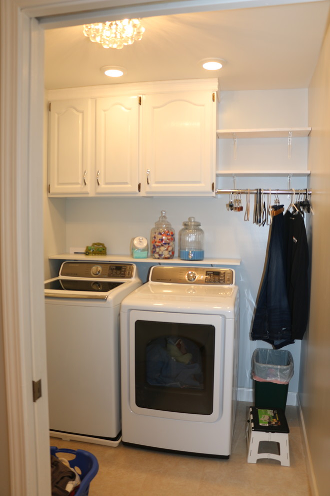 Bild på en mellanstor vintage tvättstuga enbart för tvätt, med luckor med infälld panel, vita skåp, laminatgolv och en tvättmaskin och torktumlare bredvid varandra