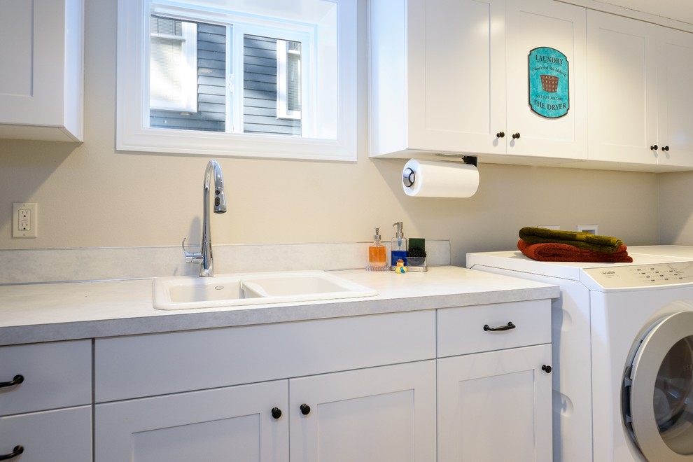 This is an example of a medium sized traditional galley separated utility room in Seattle with a built-in sink, recessed-panel cabinets, white cabinets, laminate countertops, beige walls, vinyl flooring and a side by side washer and dryer.