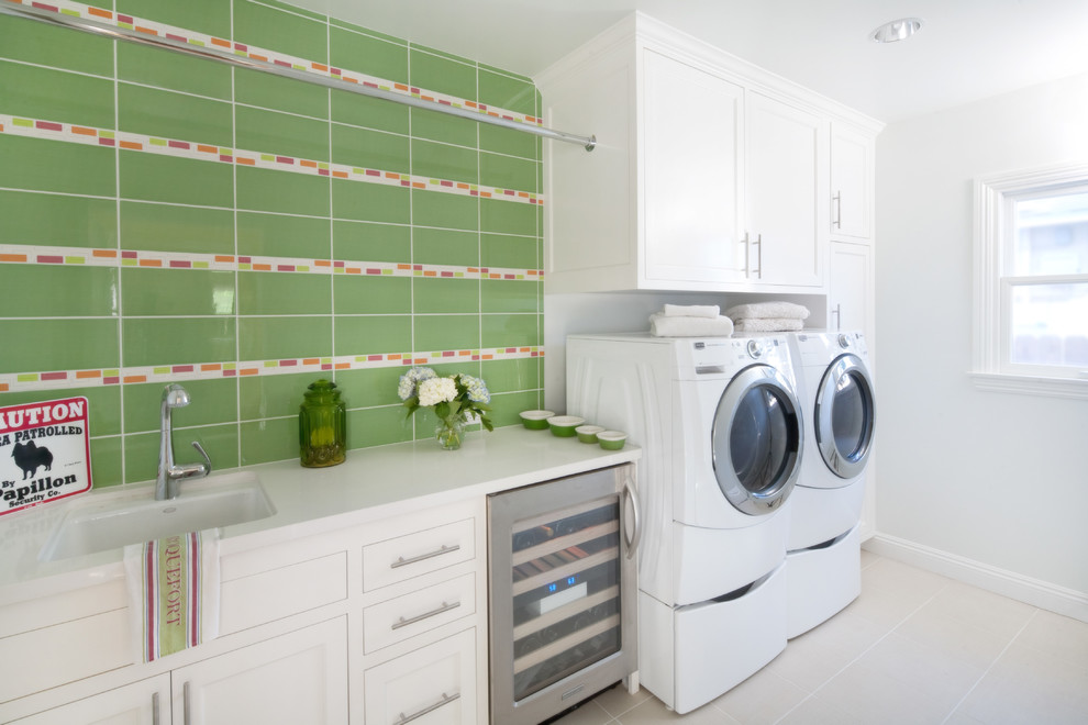 ロサンゼルスにある高級な中くらいなトランジショナルスタイルのおしゃれな洗濯室 (白いキャビネット、左右配置の洗濯機・乾燥機、シェーカースタイル扉のキャビネット、シングルシンク、I型、磁器タイルの床、グレーの壁) の写真