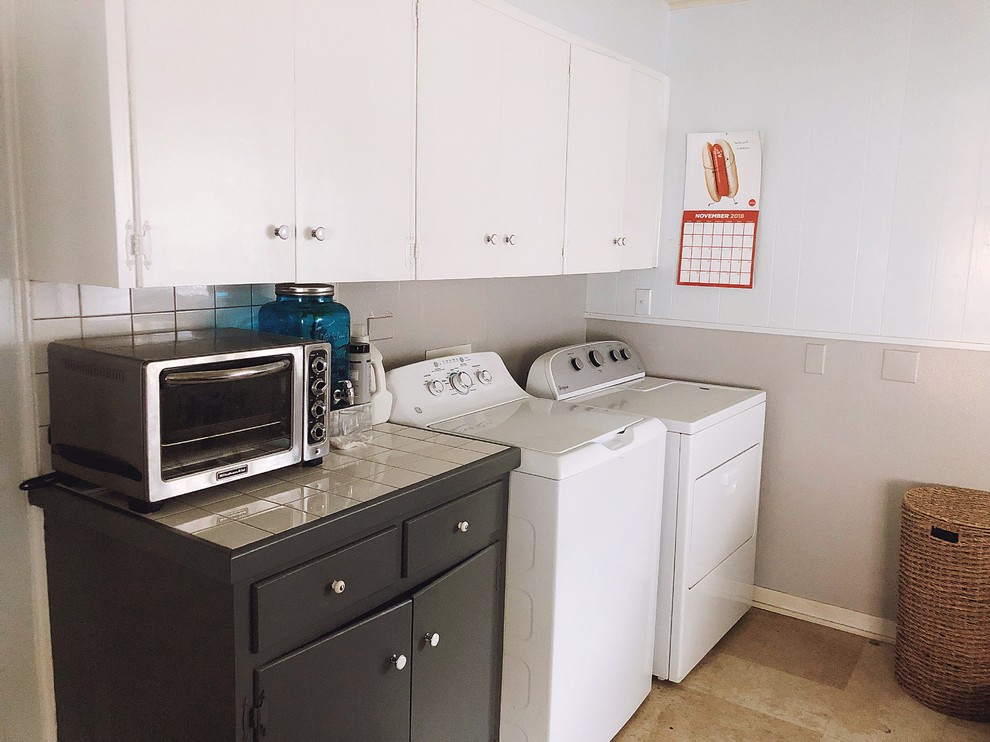 Foto på ett mellanstort retro vit linjärt grovkök, med släta luckor, vita skåp, träbänkskiva, lila väggar, vinylgolv, en tvättmaskin och torktumlare bredvid varandra och beiget golv