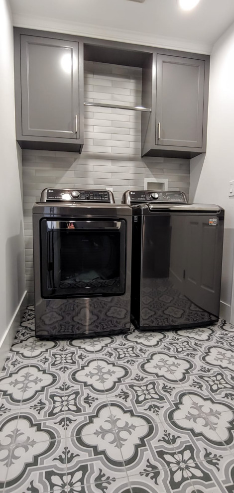 This is an example of a small bohemian u-shaped separated utility room in Los Angeles with shaker cabinets, grey cabinets, grey splashback, ceramic splashback, white walls, ceramic flooring, a side by side washer and dryer and multi-coloured floors.