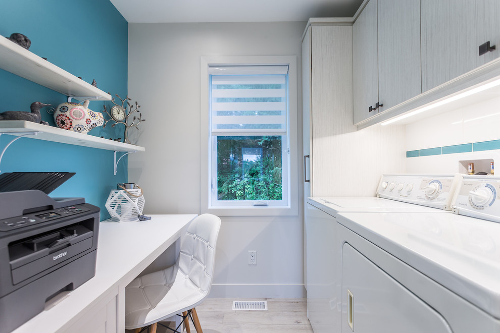 Small transitional u-shaped ceramic tile and beige floor utility room photo in Montreal with flat-panel cabinets, white cabinets, blue walls and a side-by-side washer/dryer