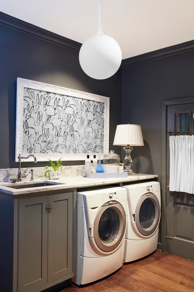 Esempio di una lavanderia multiuso classica di medie dimensioni con lavello da incasso, ante a filo, ante grigie, top in marmo, pareti grigie, parquet scuro e lavatrice e asciugatrice affiancate