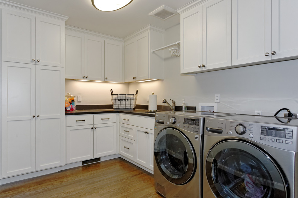 Example of a large minimalist l-shaped dedicated laundry room design in San Francisco with an undermount sink, shaker cabinets, white cabinets, quartz countertops and a side-by-side washer/dryer