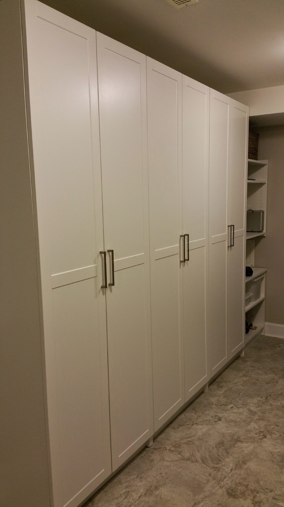 Contemporary laundry cupboard in Vancouver with white cabinets.