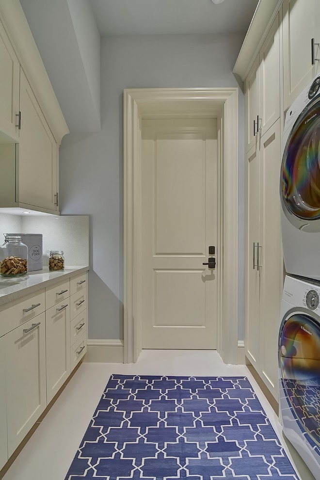 Immagine di un'ampia lavanderia chic con lavello da incasso, ante in stile shaker, top in quarzite, pavimento in gres porcellanato, lavatrice e asciugatrice a colonna, ante bianche e pareti grigie