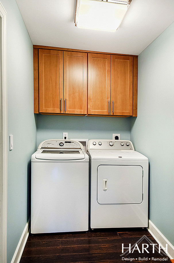 フィラデルフィアにある低価格の小さなトランジショナルスタイルのおしゃれな洗濯室 (I型、シェーカースタイル扉のキャビネット、淡色木目調キャビネット、青い壁、濃色無垢フローリング、左右配置の洗濯機・乾燥機、茶色い床) の写真