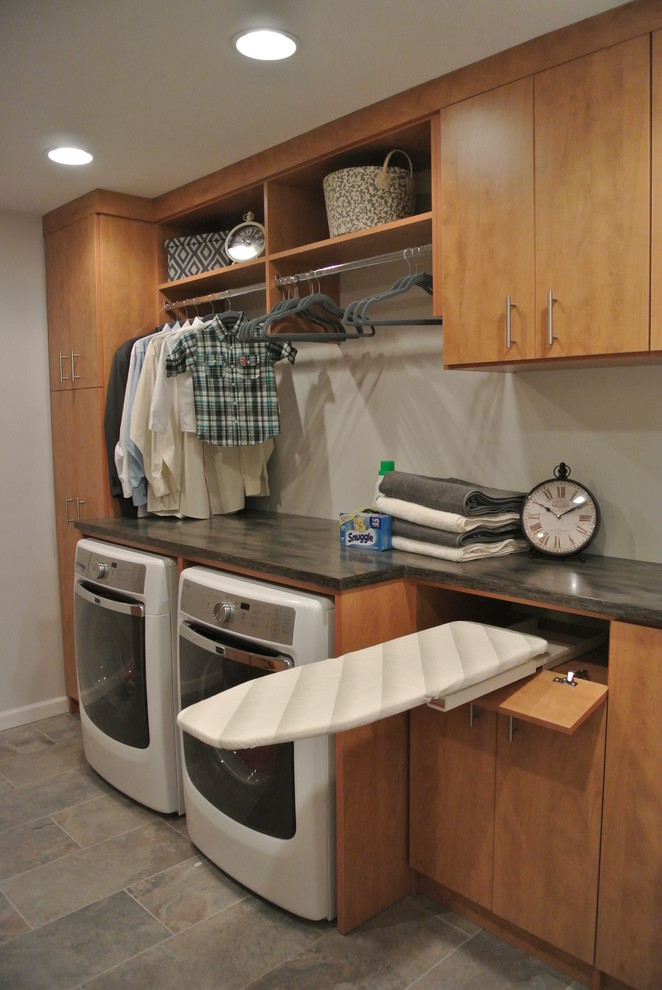 Ejemplo de lavadero tradicional de tamaño medio con armarios con paneles lisos, puertas de armario de madera oscura, paredes grises y lavadora y secadora juntas