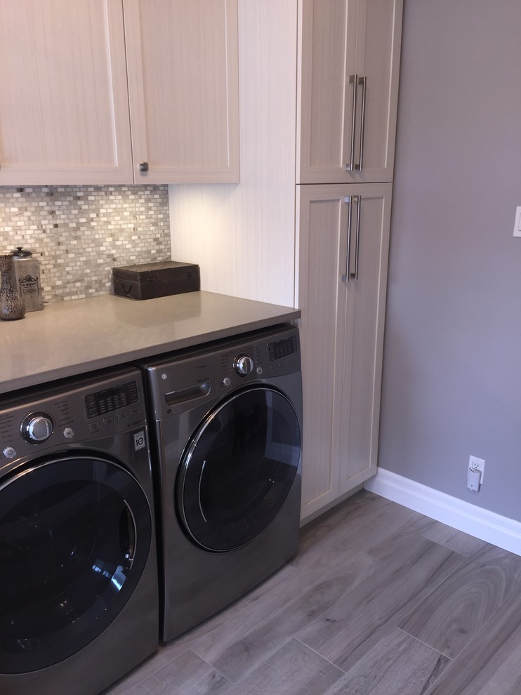 Utility room - mid-sized transitional l-shaped porcelain tile and gray floor utility room idea in Montreal with an undermount sink, shaker cabinets, beige cabinets, quartz countertops, gray walls, a side-by-side washer/dryer and beige countertops