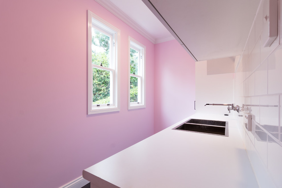 На фото: прачечная в стиле модернизм с розовыми стенами и серым полом