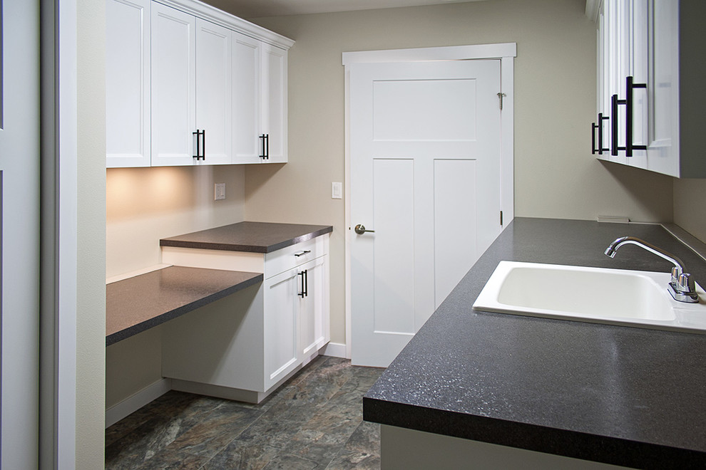 Large arts and crafts galley linoleum floor utility room photo in Seattle with a drop-in sink, recessed-panel cabinets, white cabinets, laminate countertops, gray walls and a side-by-side washer/dryer