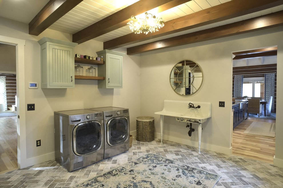 Foto di una grande lavanderia multiuso contemporanea con lavello stile country, ante a filo, ante blu, pareti grigie, pavimento con piastrelle in ceramica, lavatrice e asciugatrice affiancate e pavimento grigio