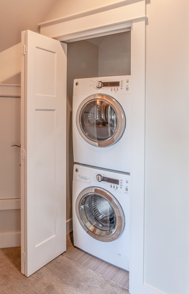 Idee per un piccolo ripostiglio-lavanderia chic con pareti bianche, pavimento in linoleum e lavatrice e asciugatrice a colonna