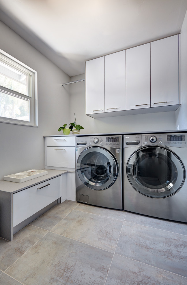 Inspiration for a mid-sized modern galley porcelain tile utility room remodel in Sacramento with an undermount sink, flat-panel cabinets, white cabinets, quartz countertops, gray walls and a side-by-side washer/dryer